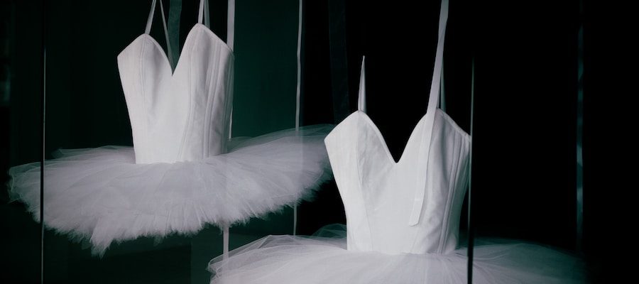 a couple of white ballet shoes sitting on top of a floor