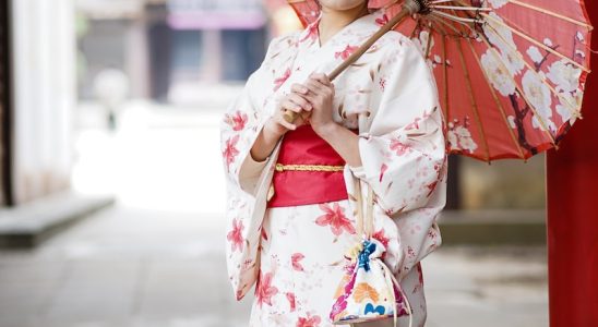 woman in white and red kimono holding umbrella