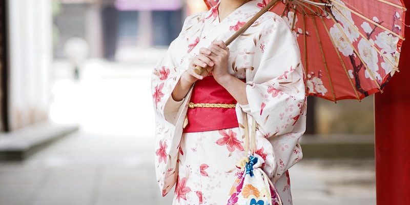 woman in white and red kimono holding umbrella