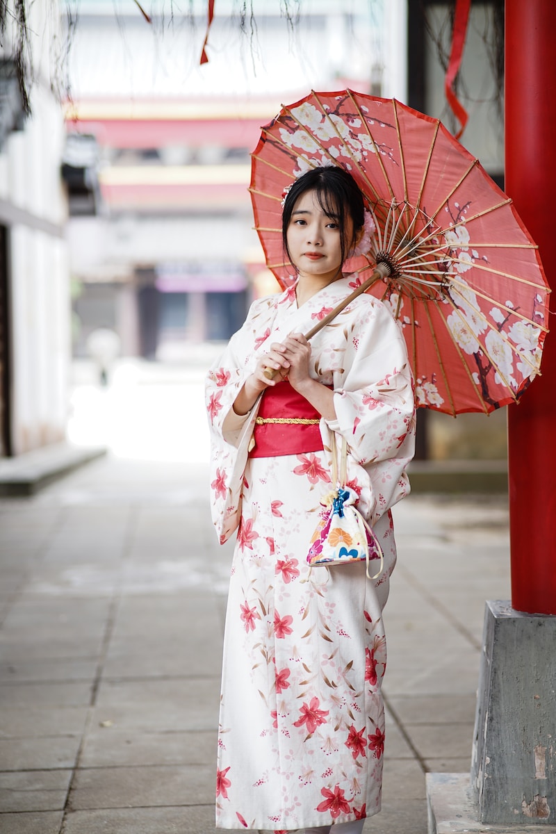 woman in white and red kimono holding umbrella