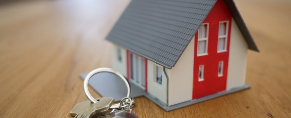 white and red wooden house miniature on brown table